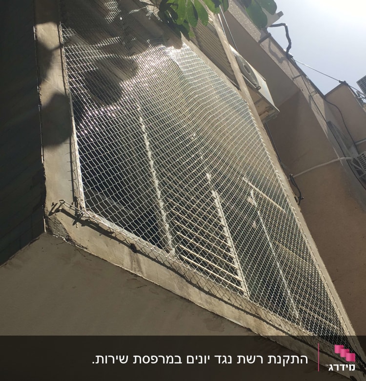 רשת מתכת מותקנת על חלון למניעת כניסת יונים